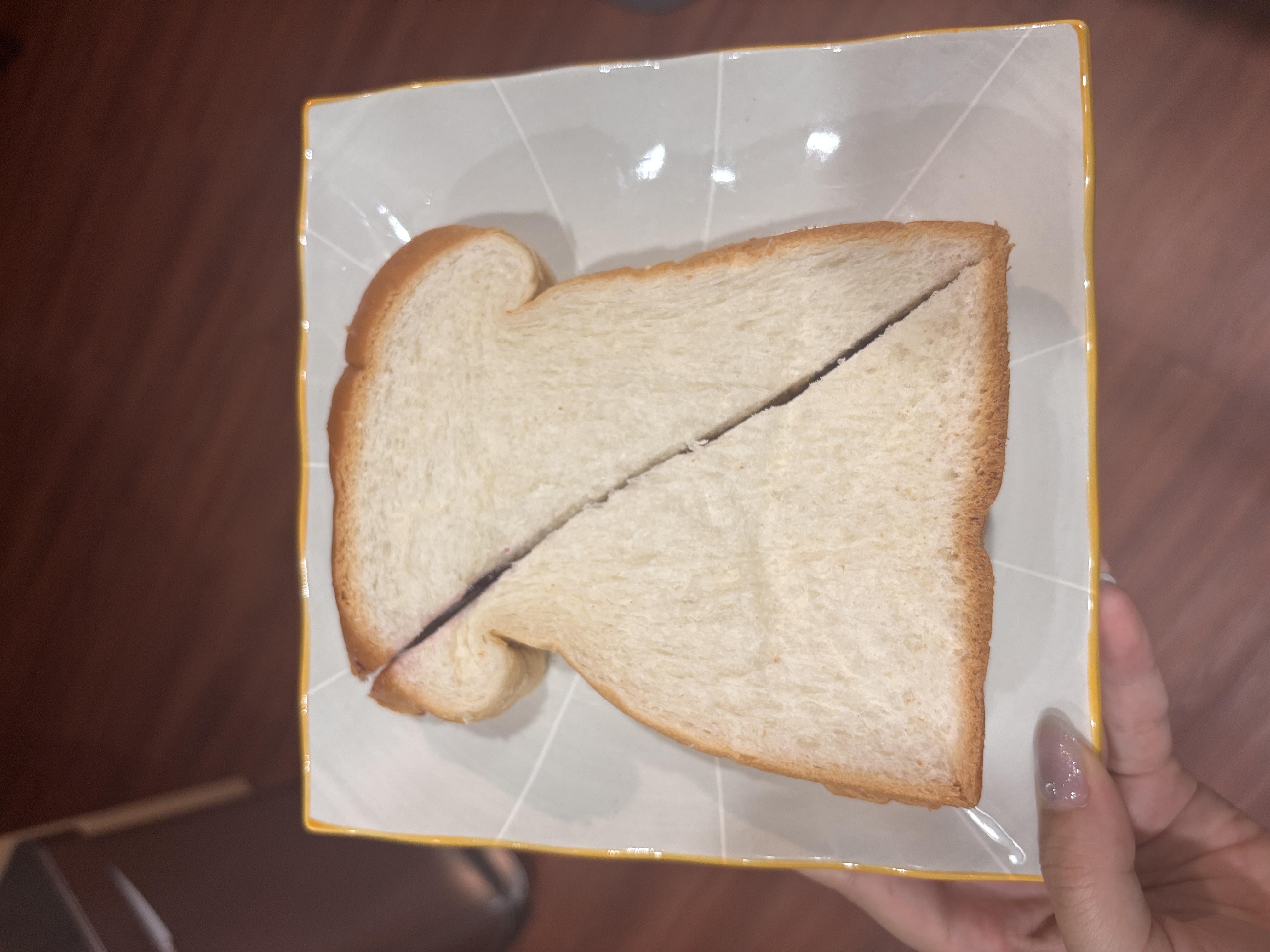 PB&J sandwich cut in half on a plate